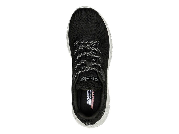 Tenis Skechers negros con suela blanca moteada y tejido transpirable.