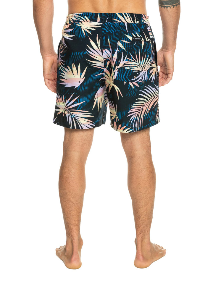 Shorts de baño color negro con estampado de hojas tropicales en tonos amarillo y naranja.