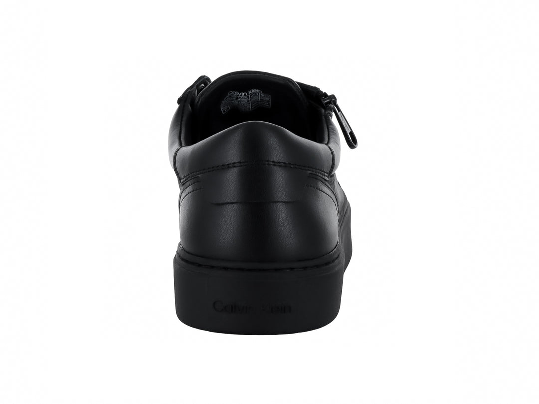 Tenis negros de Calvin Klein con cordones, cierre lateral y suela plana.