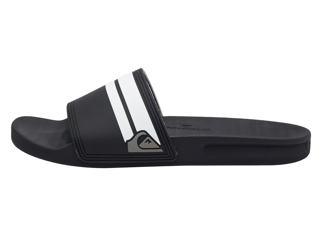 Sandalia slide Quiksilver de color negro con dos franjas blancas laterales y suela negra.
