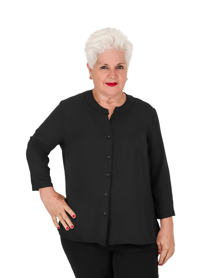 Mujer vistiendo blusa negra de manga 3/4 con botones frontales y cuello redondo.