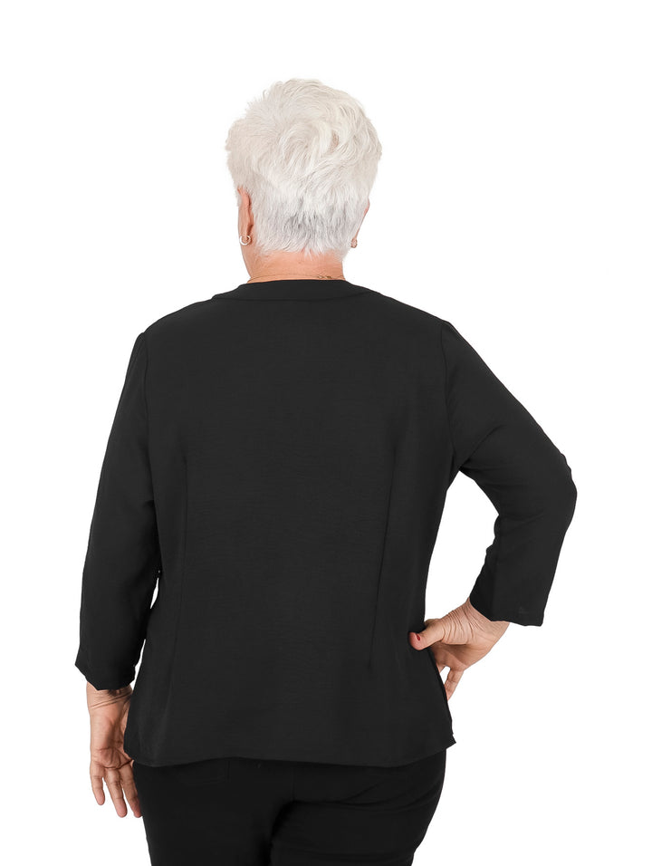 Mujer vistiendo blusa negra de manga 3/4 con botones frontales y cuello redondo.