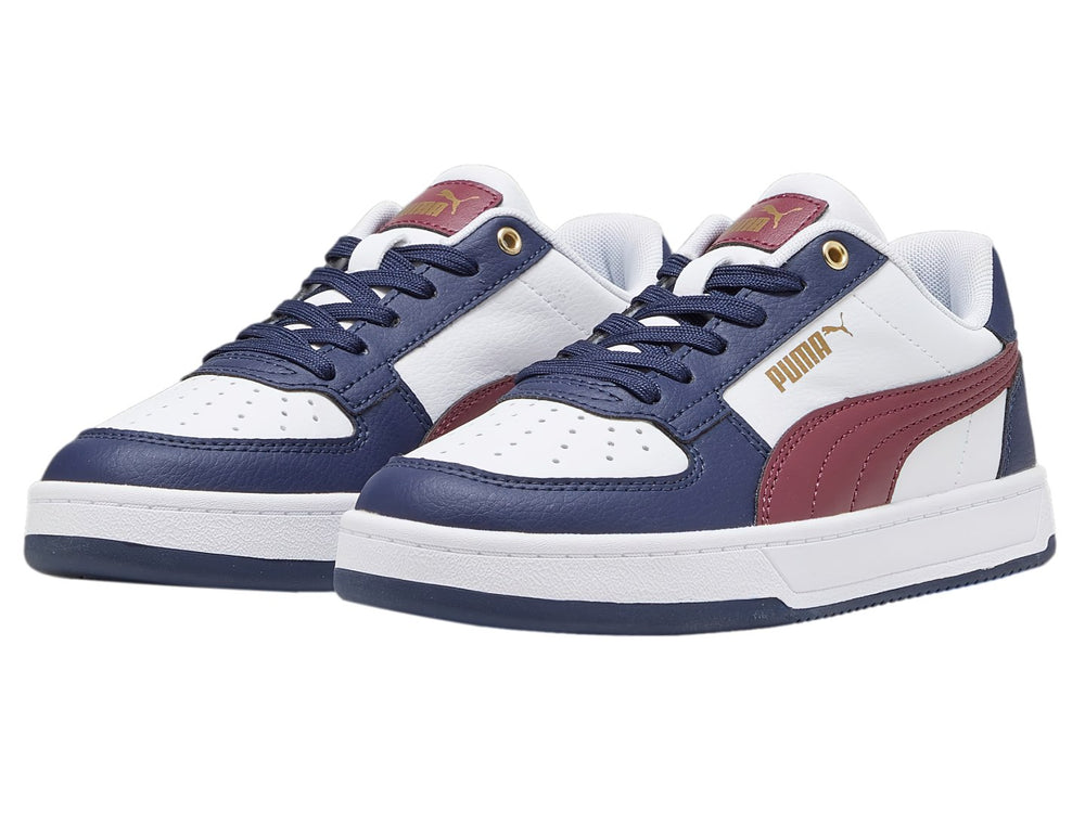 Tenis PUMA Caven 2.0 JR en colores blanco, azul marino y guinda con detalles dorados.