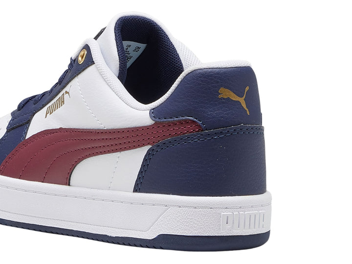 Tenis PUMA Caven 2.0 JR en colores blanco, azul marino y guinda con detalles dorados.