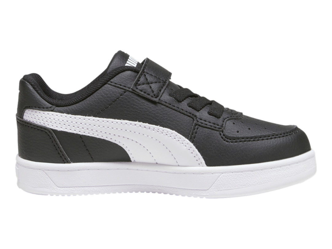 Tenis PUMA negros con suela blanca y franja lateral blanca para niños.