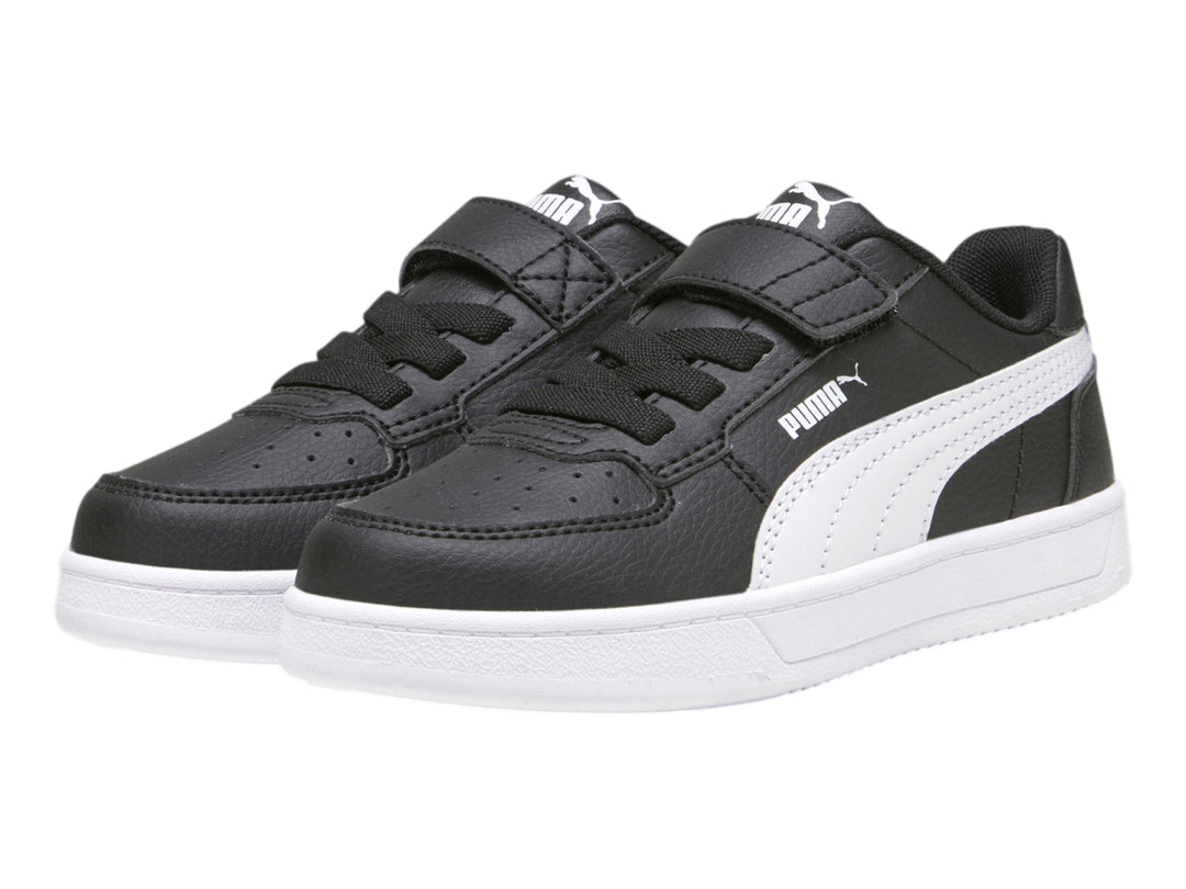 Tenis PUMA negros con suela blanca y franja lateral blanca para niños.
