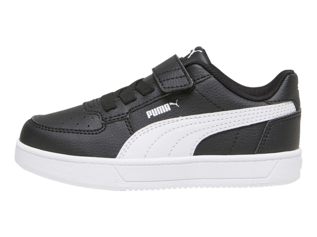 Tenis PUMA negros con suela blanca y franja lateral blanca para niños.