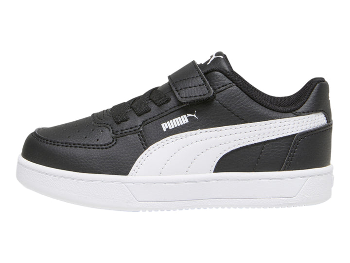 Tenis PUMA negros con suela blanca y franja lateral blanca para niños.