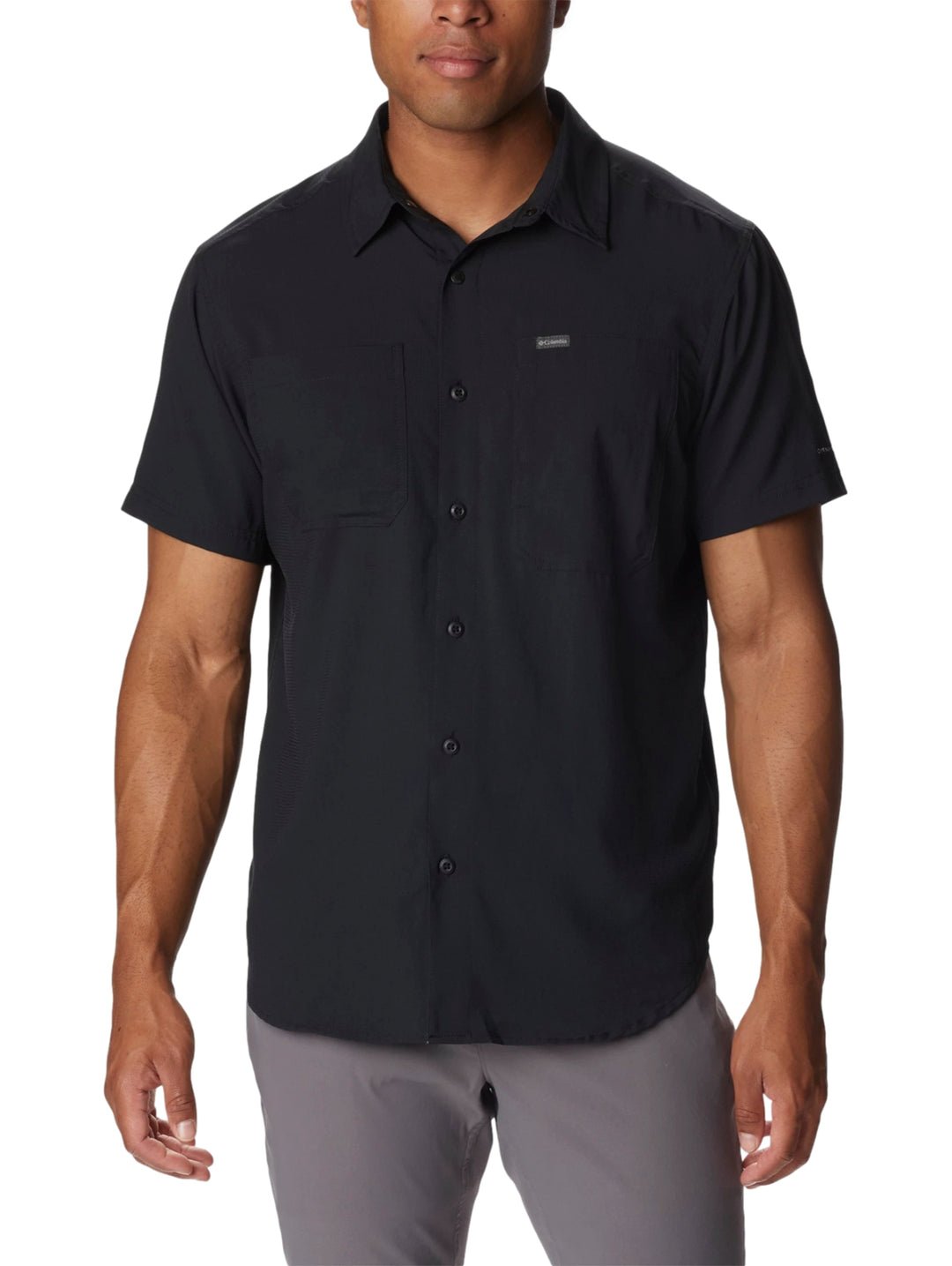 Hombre vistiendo una camisa Columbia de manga corta en color negro con botones frontales.