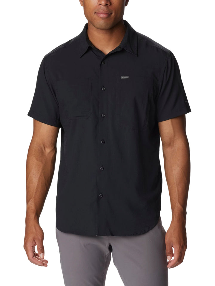Hombre vistiendo una camisa Columbia de manga corta en color negro con botones frontales.