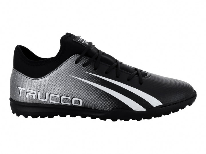 Zapato de fútbol Leon Trucco en color negro y plateado con franjas blancas laterales y suela negra.