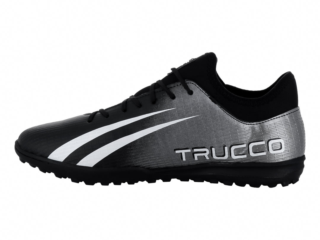 Zapato de fútbol Leon Trucco en color negro y plateado con franjas blancas laterales y suela negra.