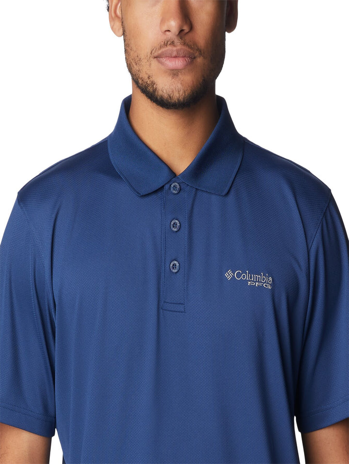 Hombre vistiendo una playera polo de color azul marca Columbia con cuello y botones.