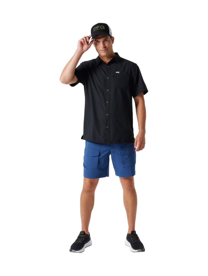 Hombre vistiendo una camisa Columbia de manga corta color negro con botones y bolsillo frontal.