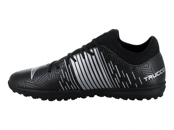 Zapato de fútbol Leon Trucco color negro con detalles lineales en plata y suela para césped sintético.