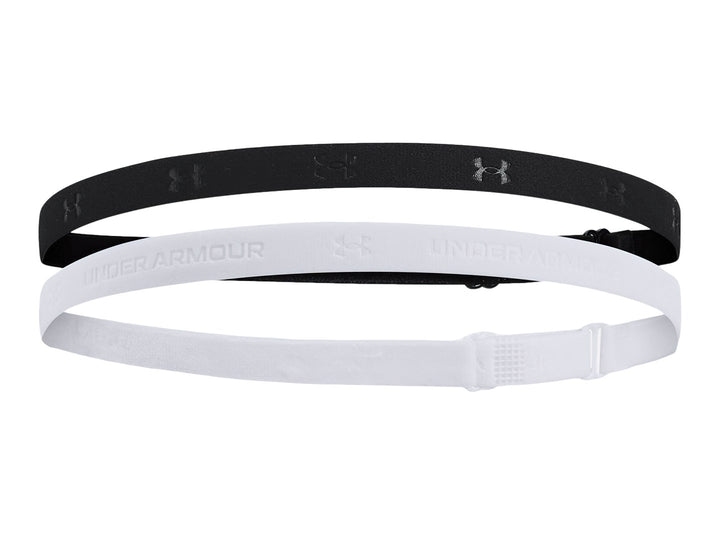 Set de dos bandas elásticas ajustables Under Armour en colores negro y blanco sobre fondo blanco.