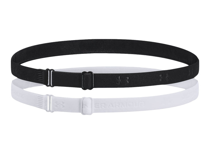 Set de dos bandas elásticas ajustables Under Armour en colores negro y blanco sobre fondo blanco.
