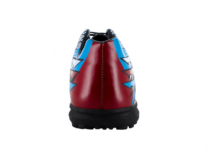 Zapato de fútbol Leon Trucco color negro con gráficos en azul y rojo, suela para turf.