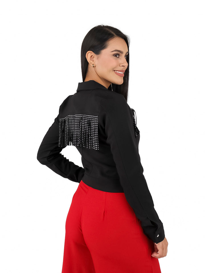 Mujer vistiendo chaqueta corta negra con detalles de flecos en el pecho y botones plateados.