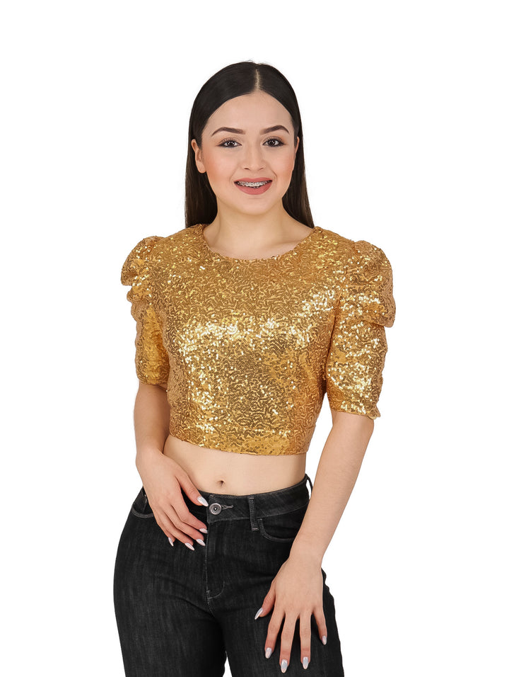 Mujer modelando un crop top dorado con lentejuelas y manga corta.