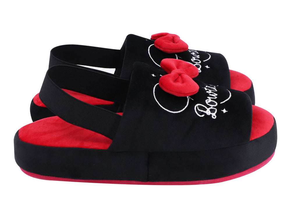 Par de pantuflas negras y rojas con un moño rojo decorativo y texto bordado en blanco.