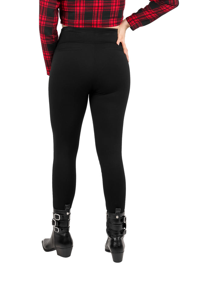 Mujer vistiendo leggings negros de pretina ancha y botas negras.