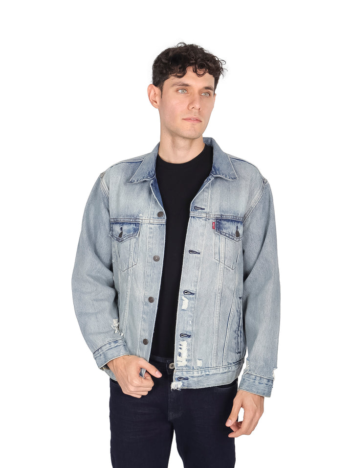 Hombre modelando una chaqueta de mezclilla azul claro de corte relajado.
