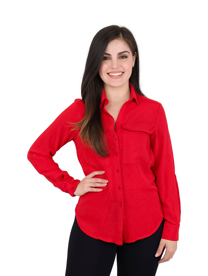 Mujer vistiendo una camisa roja de manga larga con botones y bolsillos frontales.