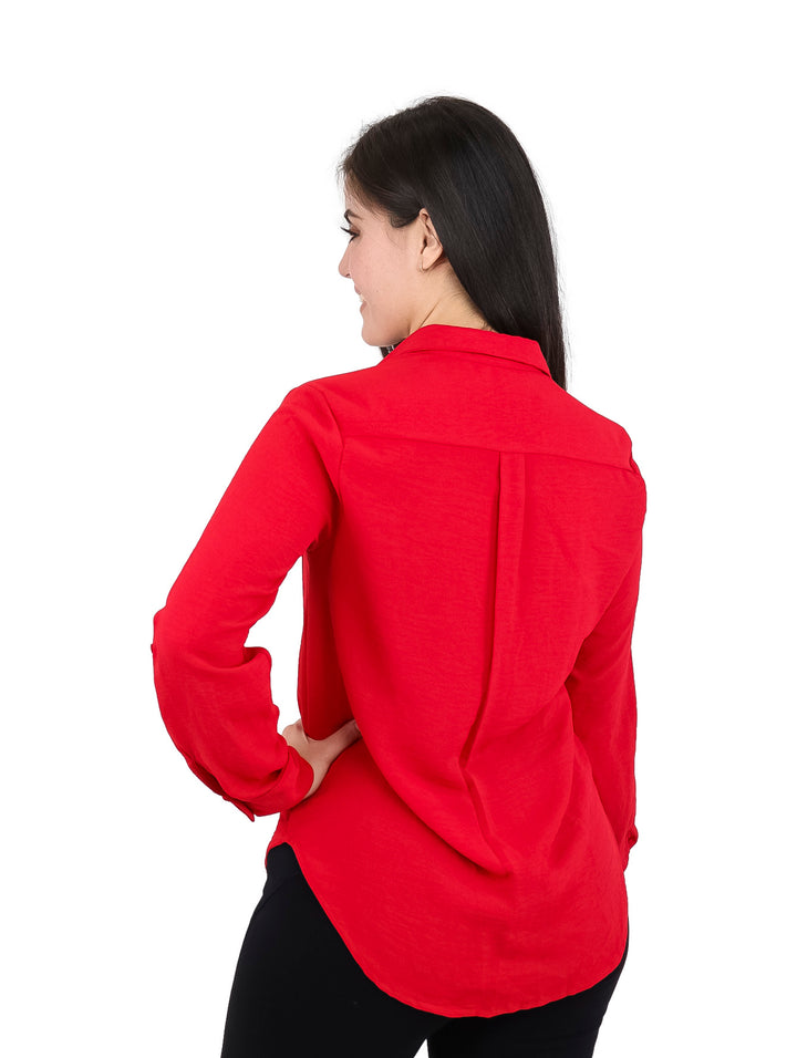 Mujer vistiendo una camisa roja de manga larga con botones y bolsillos frontales.