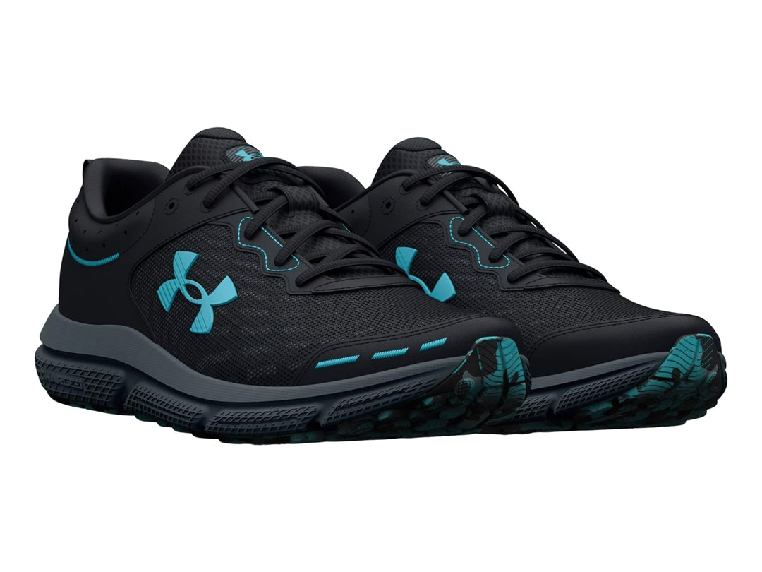 Tenis deportivos Under Armour color negro con suela gris y detalles en azul claro.