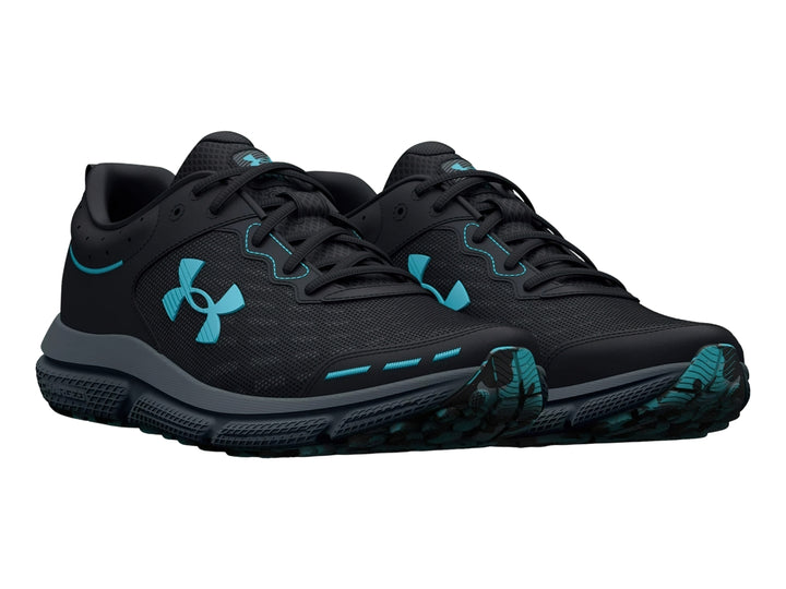 Tenis deportivos Under Armour color negro con suela gris y detalles en azul claro.