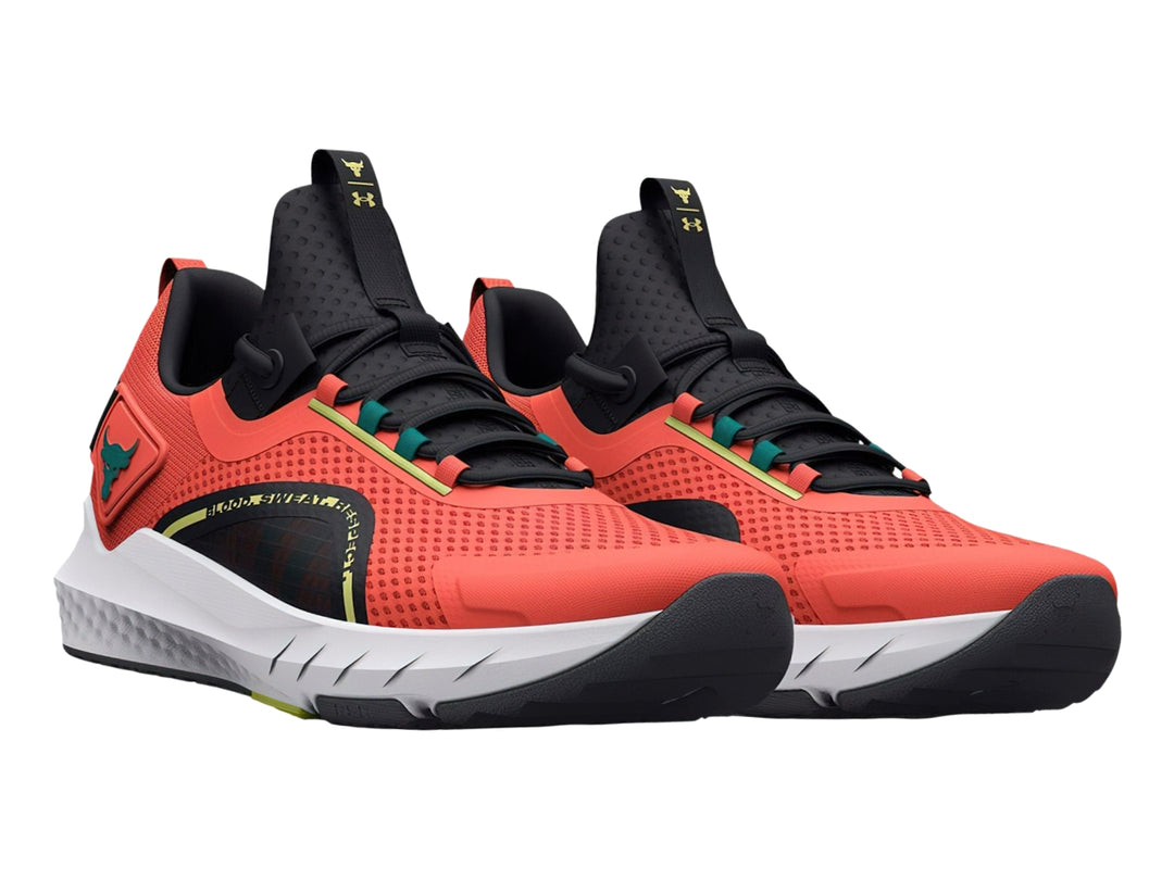 Tenis deportivos Under Armour Project Rock color naranja con suela blanca y detalles en negro y verde.