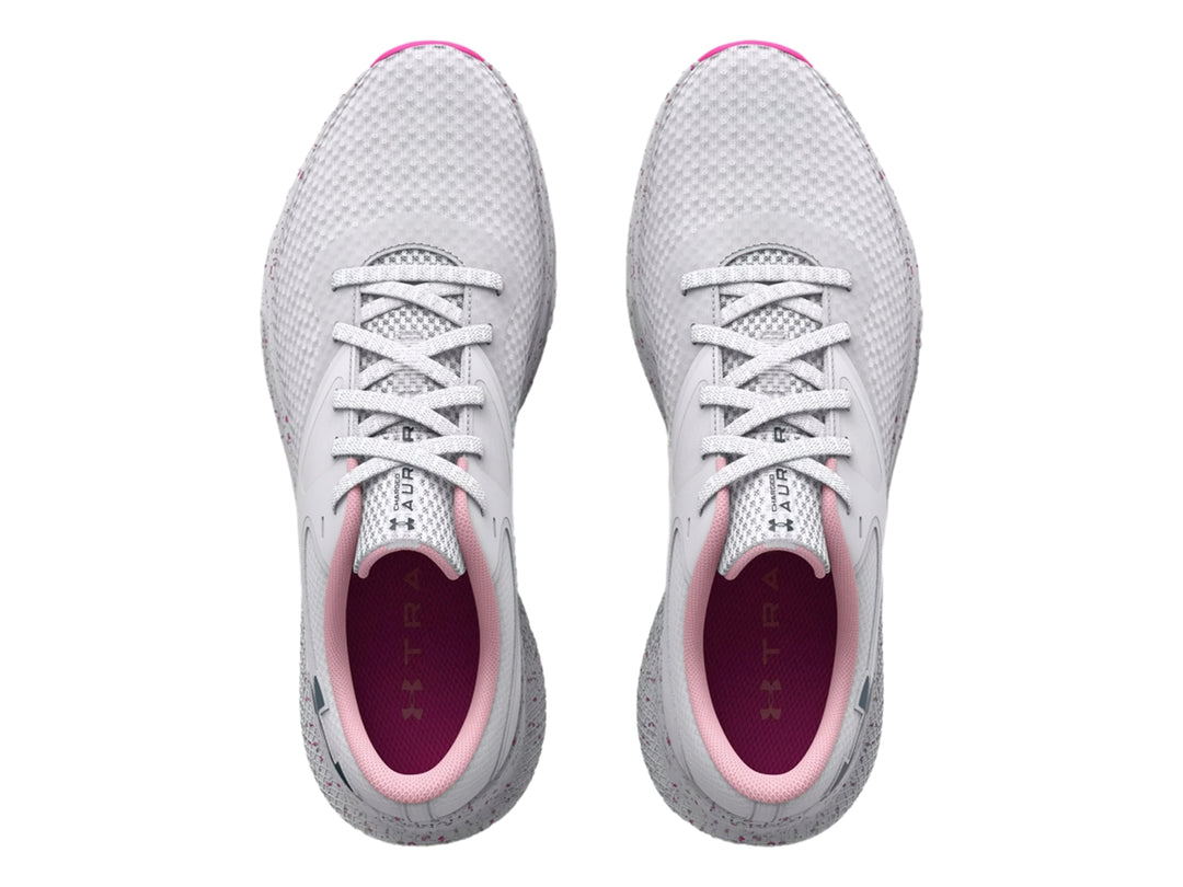 Tenis deportivos Under Armour color blanco con detalles en rosa y suela moteada.