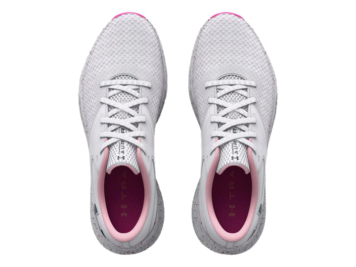Tenis deportivos Under Armour color blanco con detalles en rosa y suela moteada.