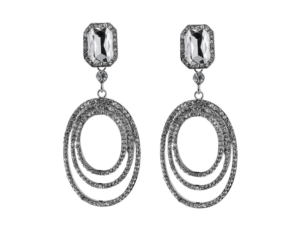 Pendientes largos de color plata con una piedra rectangular superior y tres aros ovalados brillantes colgantes.