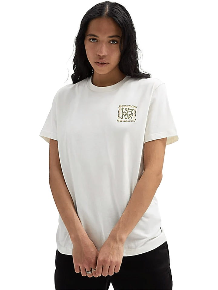 Mujer vistiendo una playera blanca de manga corta con un pequeño gráfico en el pecho.