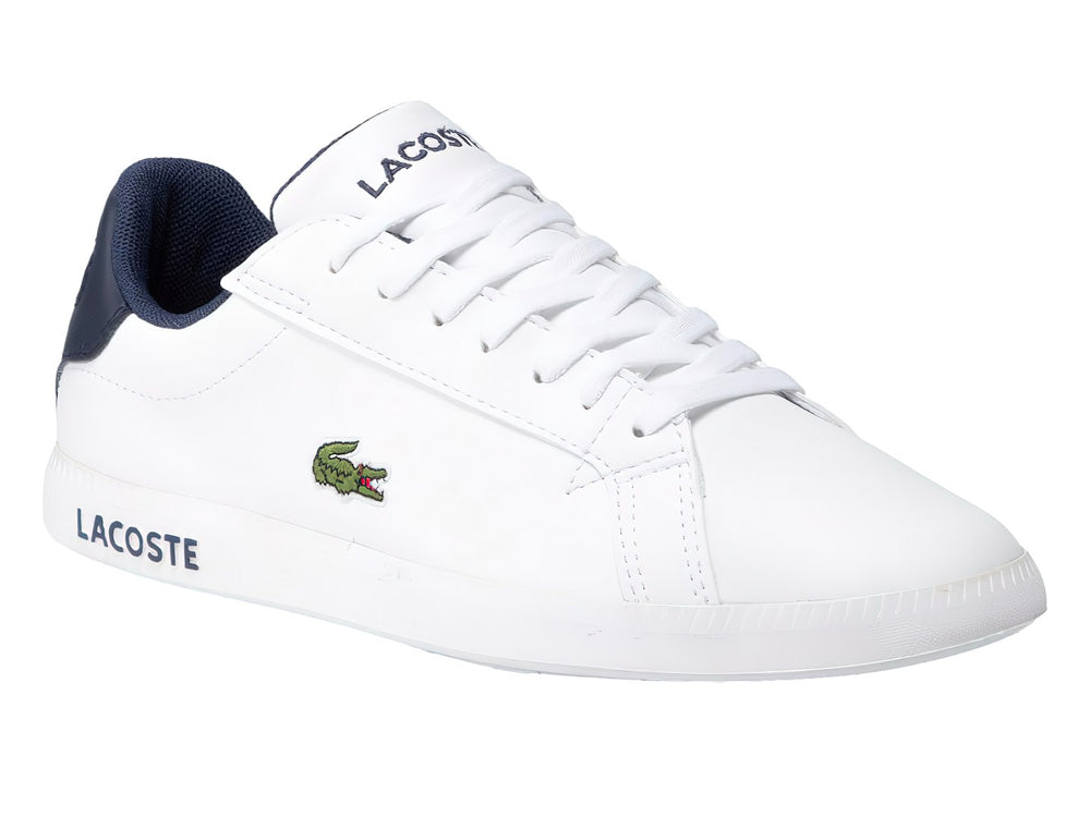 Tenis Lacoste blancos con detalles en azul marino y logotipo de cocodrilo verde en el lateral.