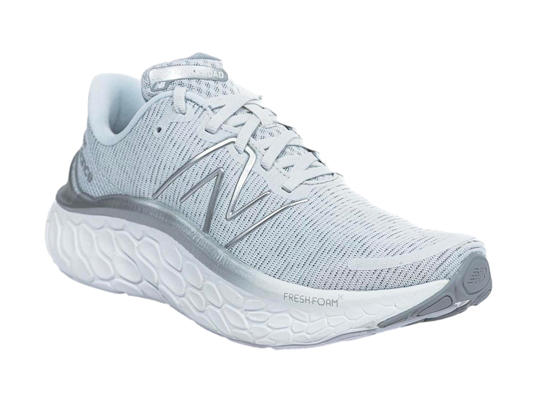 Tenis New Balance color gris con suela blanca gruesa y diseño de tejido transpirable.
