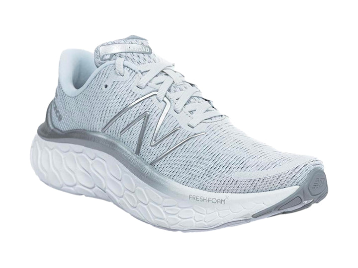 Tenis New Balance color gris con suela blanca gruesa y diseño de tejido transpirable.