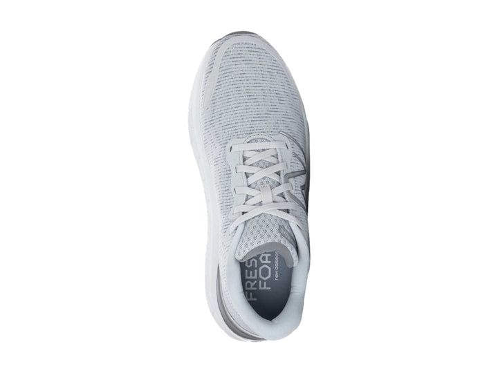 Tenis New Balance color gris con suela blanca gruesa y diseño de tejido transpirable.