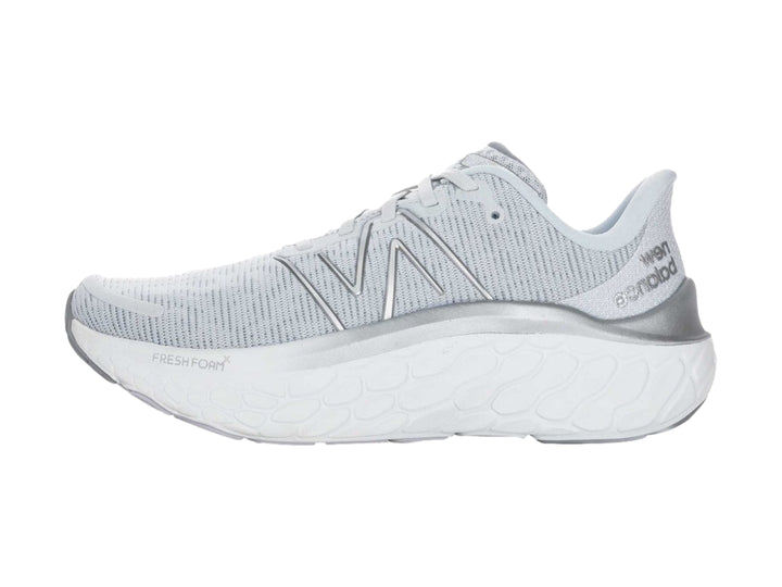 Tenis New Balance color gris con suela blanca gruesa y diseño de tejido transpirable.