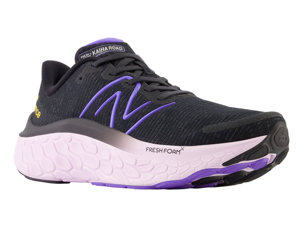 Tenis New Balance color negro con suela gruesa en tono morado claro y detalles en morado.