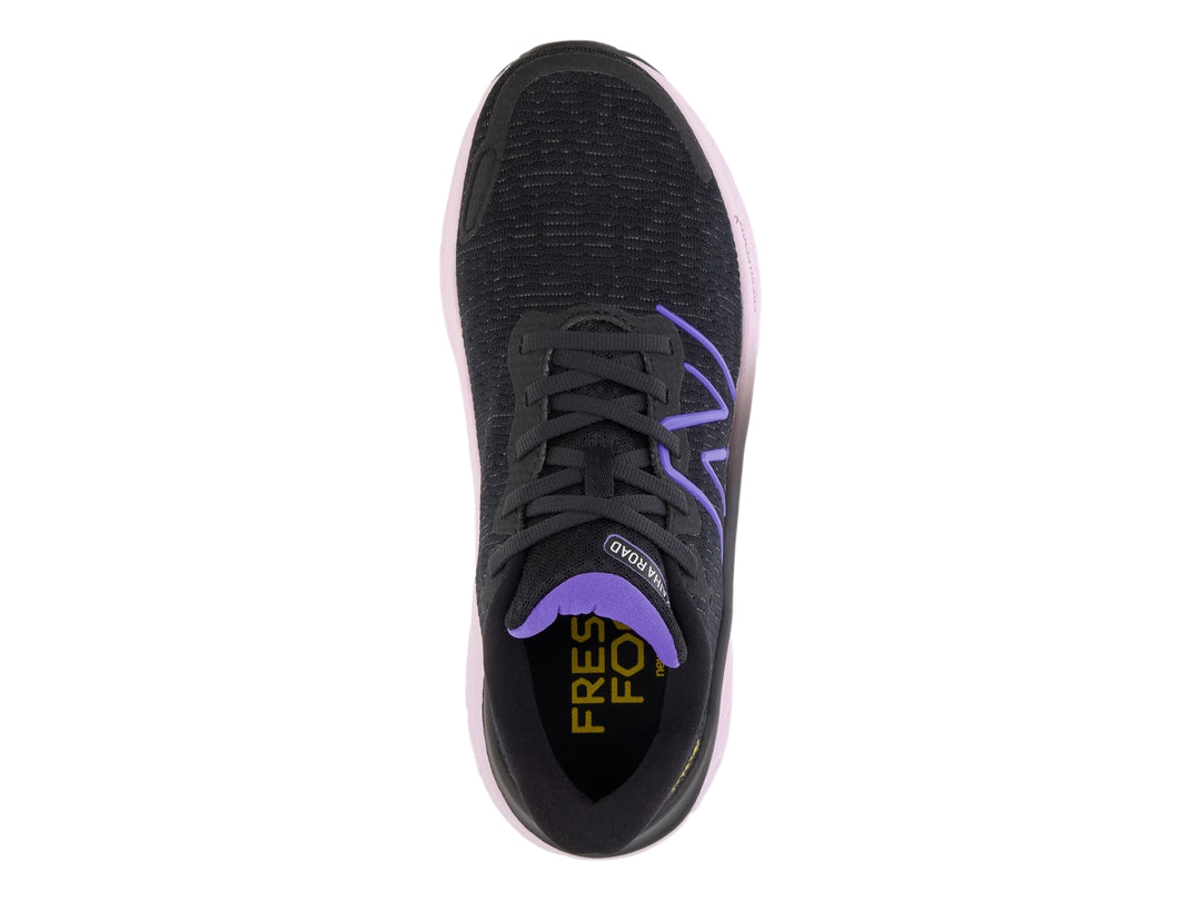 Tenis New Balance color negro con suela gruesa en tono morado claro y detalles en morado.