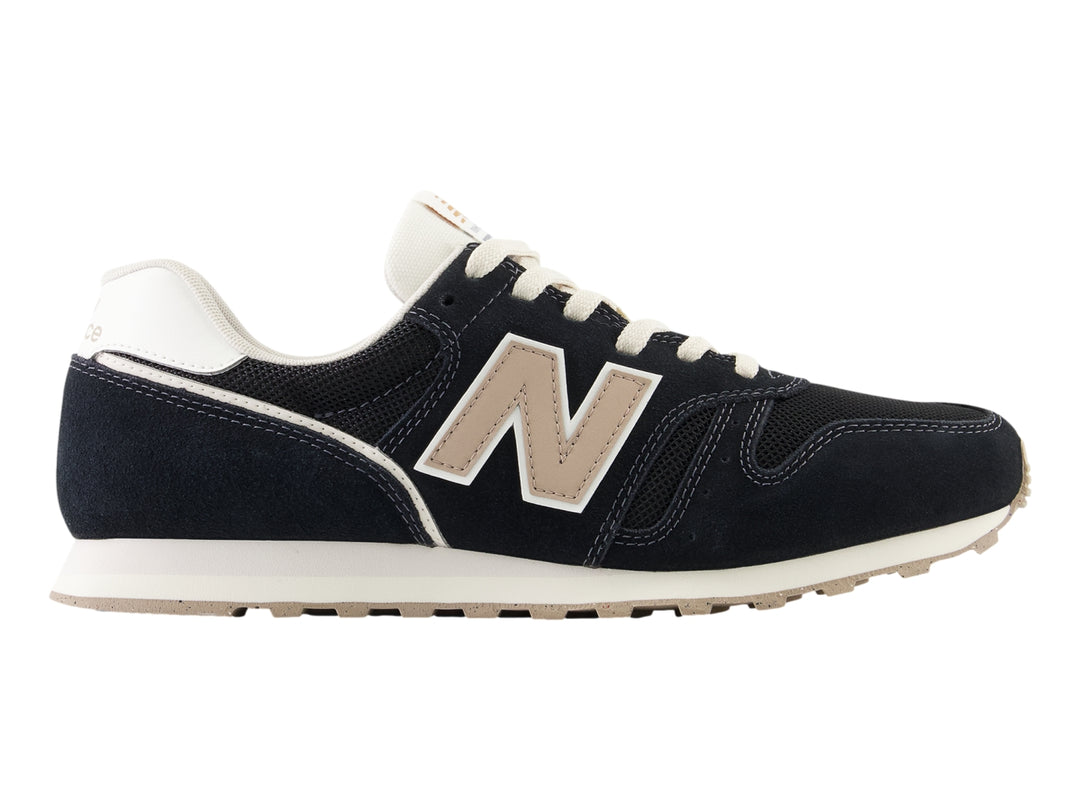 Tenis New Balance modelo 373 en color negro con detalles en blanco y beige, vista lateral.