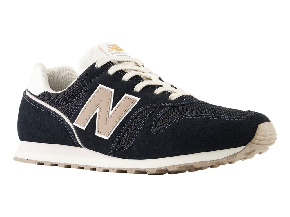 Tenis New Balance modelo 373 en color negro con detalles en blanco y beige, vista lateral.