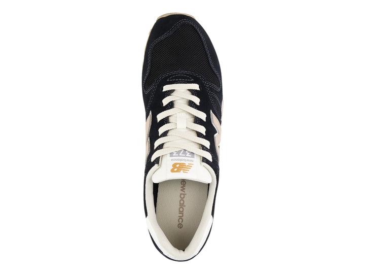 Tenis New Balance modelo 373 en color negro con detalles en blanco y beige, vista lateral.