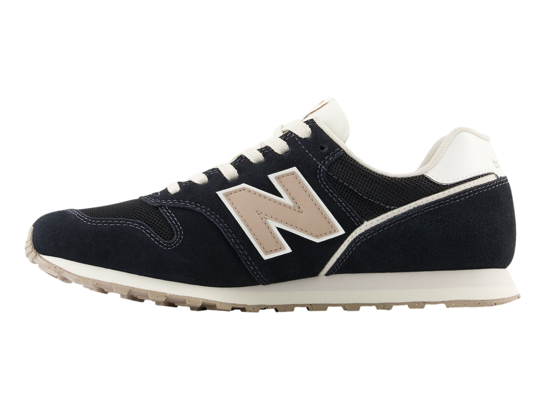 Tenis New Balance modelo 373 en color negro con detalles en blanco y beige, vista lateral.