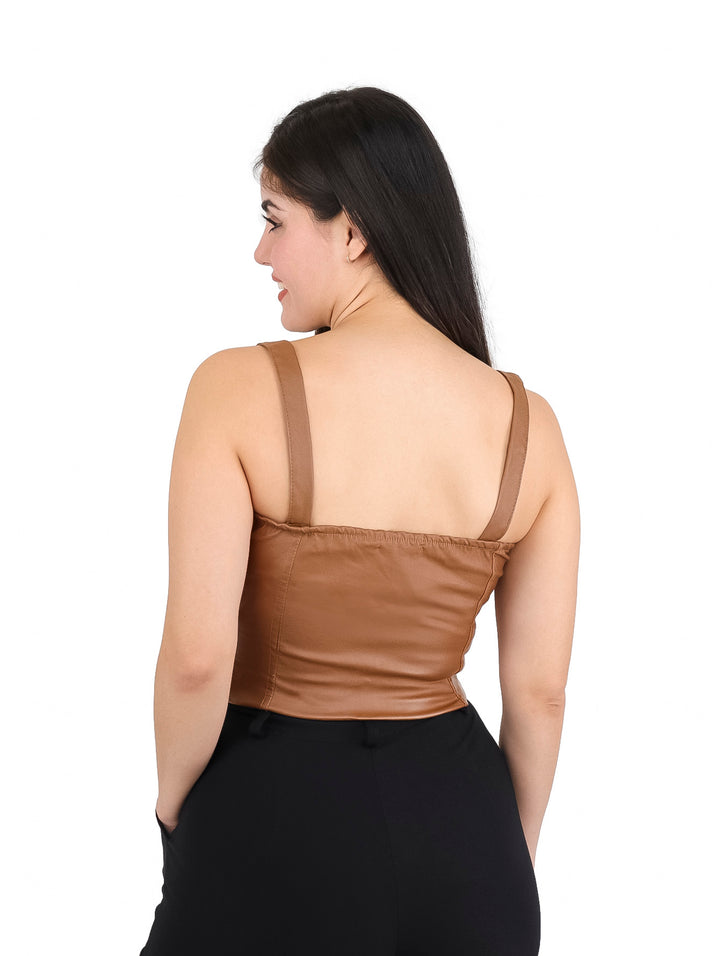 Mujer vistiendo un top ajustado de vinipiel color camel con cierre frontal y copas.
