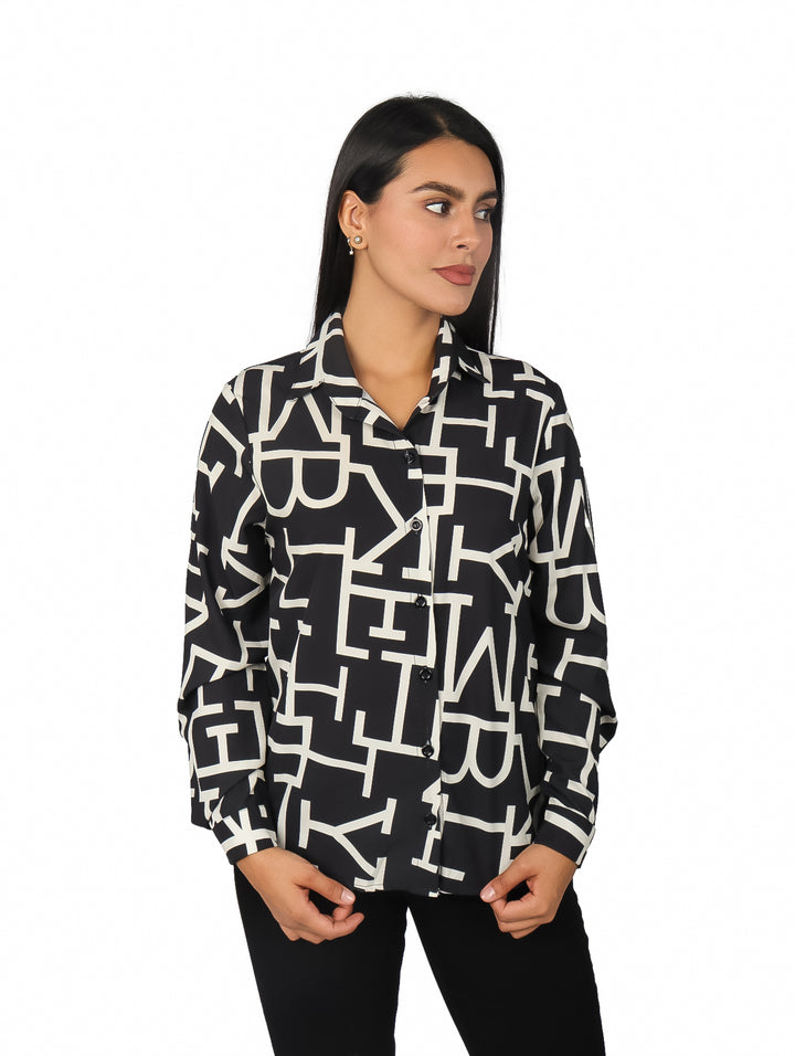 Mujer vistiendo camisa negra de manga larga con estampado gráfico en color blanco.