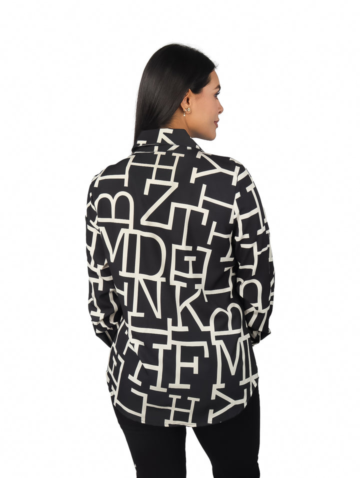 Mujer vistiendo camisa negra de manga larga con estampado gráfico en color blanco.